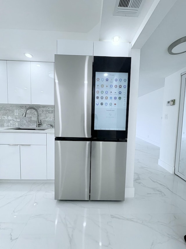 room details featuring baseboards, visible vents, a sink, smart refrigerator, and tasteful backsplash