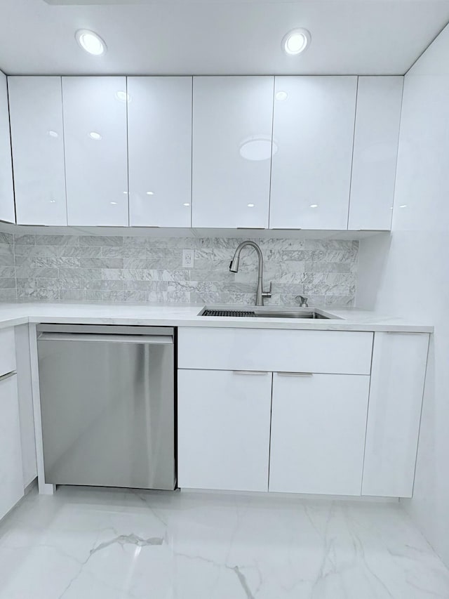 kitchen with white cabinetry, a sink, light countertops, stainless steel dishwasher, and modern cabinets