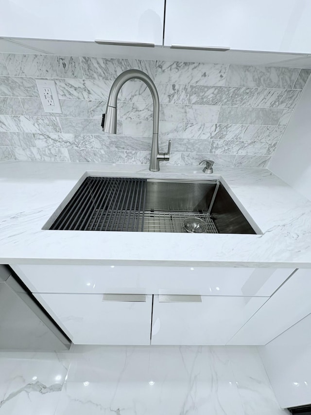 details with a sink and light stone countertops