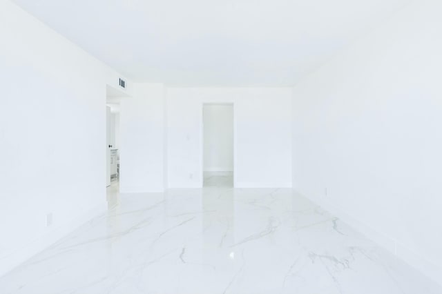 unfurnished room with visible vents, marble finish floor, and baseboards