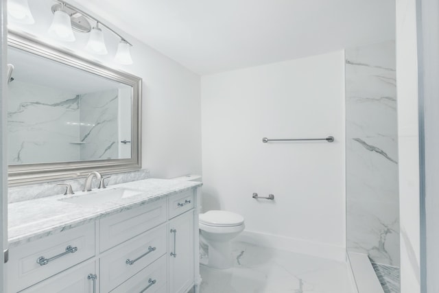 bathroom featuring toilet, marble finish floor, a marble finish shower, baseboards, and vanity