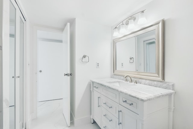 bathroom featuring baseboards, marble finish floor, and vanity