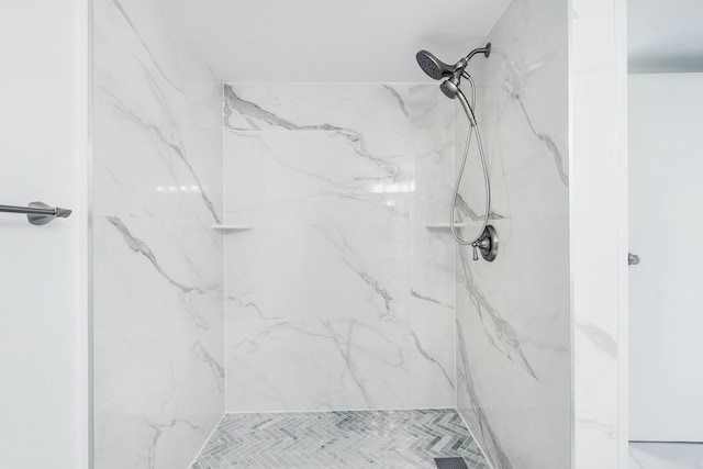 bathroom featuring a marble finish shower