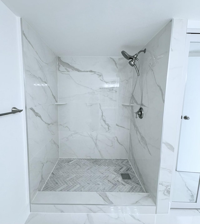 bathroom with a marble finish shower and marble finish floor