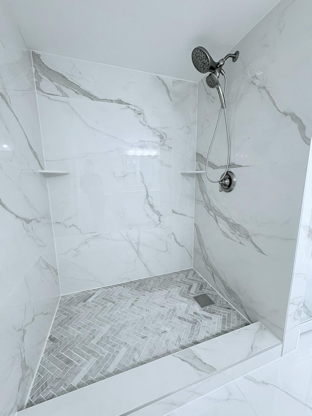 full bathroom with a marble finish shower