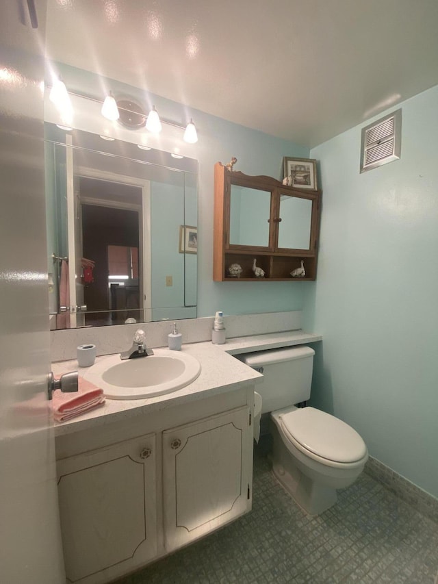 bathroom with visible vents, toilet, vanity, and baseboards