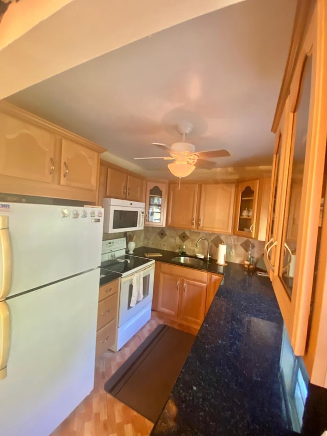 kitchen with glass insert cabinets, decorative backsplash, white appliances, a ceiling fan, and a sink