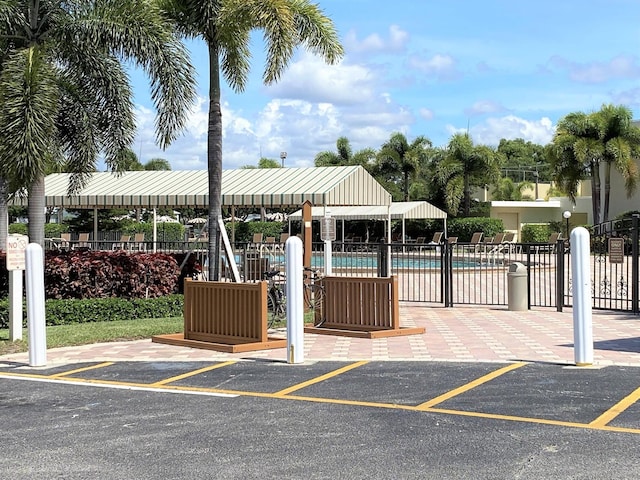 view of property's community featuring a pool and fence