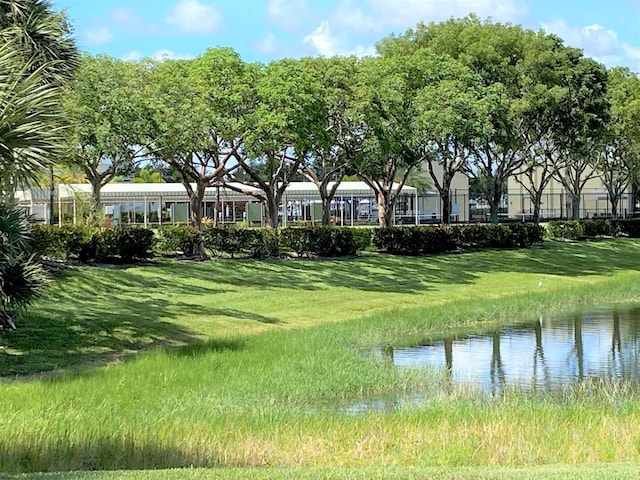 view of community featuring a water view and a lawn