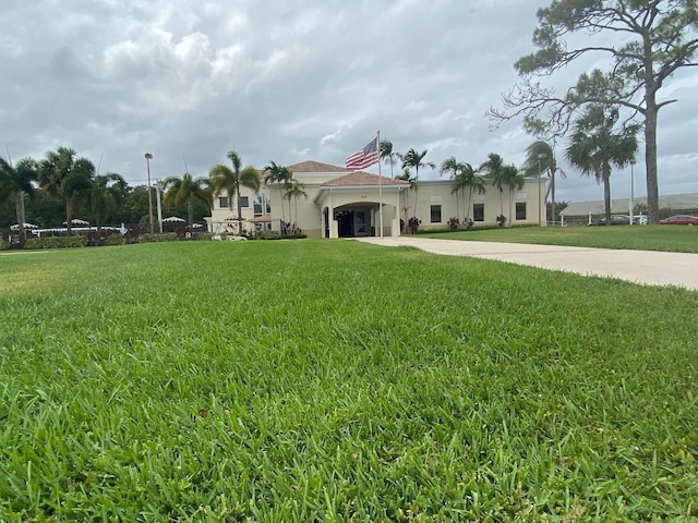 view of front of property featuring stucco siding, driveway, and a front yard