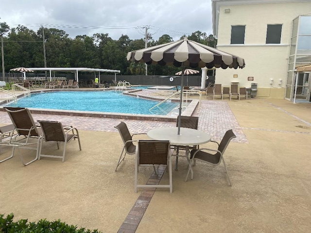 pool with a patio and fence