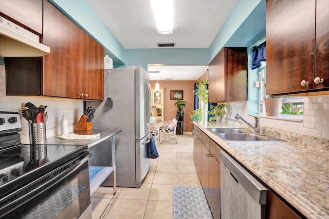 kitchen featuring visible vents, under cabinet range hood, light tile patterned floors, stainless steel appliances, and a sink