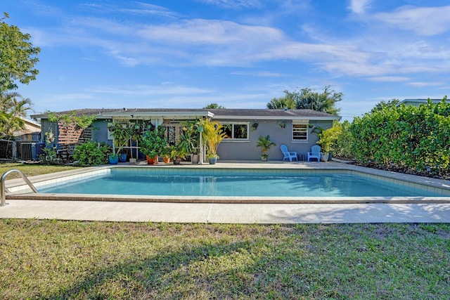 outdoor pool with a yard and a patio