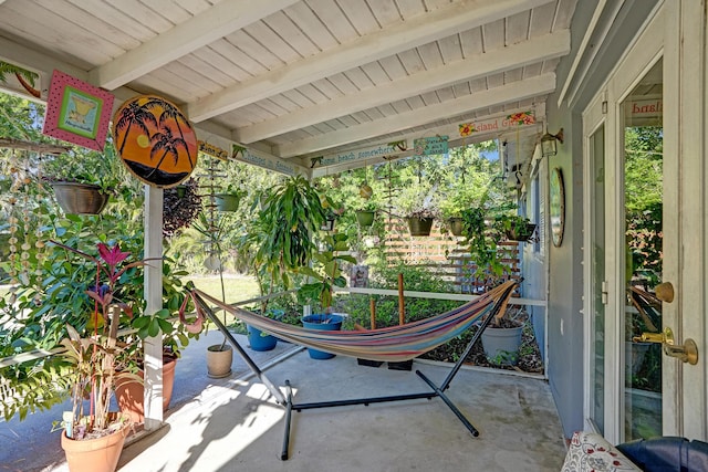 unfurnished sunroom with beamed ceiling