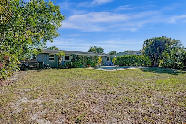 view of yard featuring a gate, an attached carport, an outdoor pool, and fence