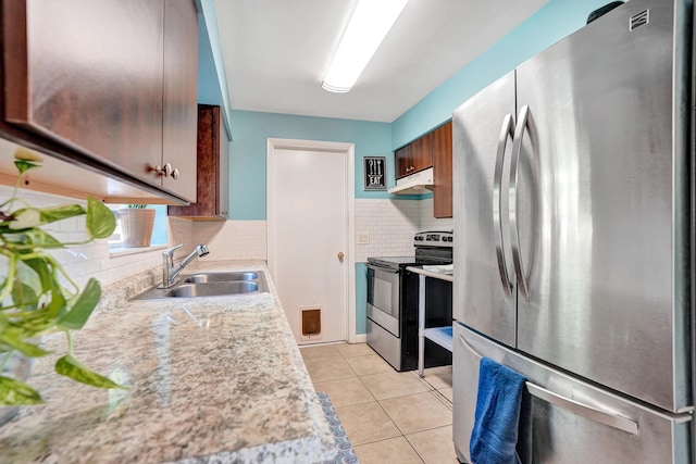 kitchen with a sink, under cabinet range hood, stainless steel appliances, light countertops, and light tile patterned floors