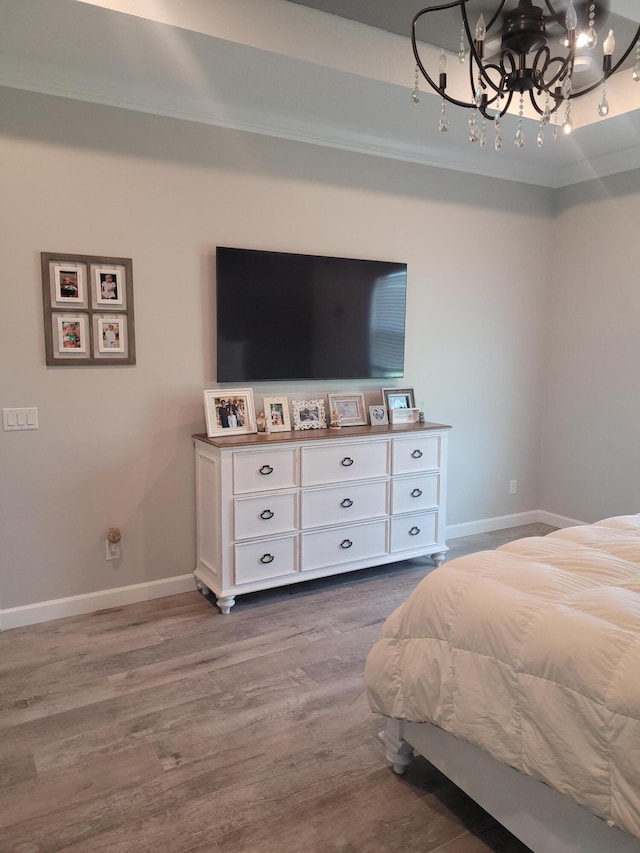 bedroom featuring baseboards, an inviting chandelier, ornamental molding, and dark wood-style flooring