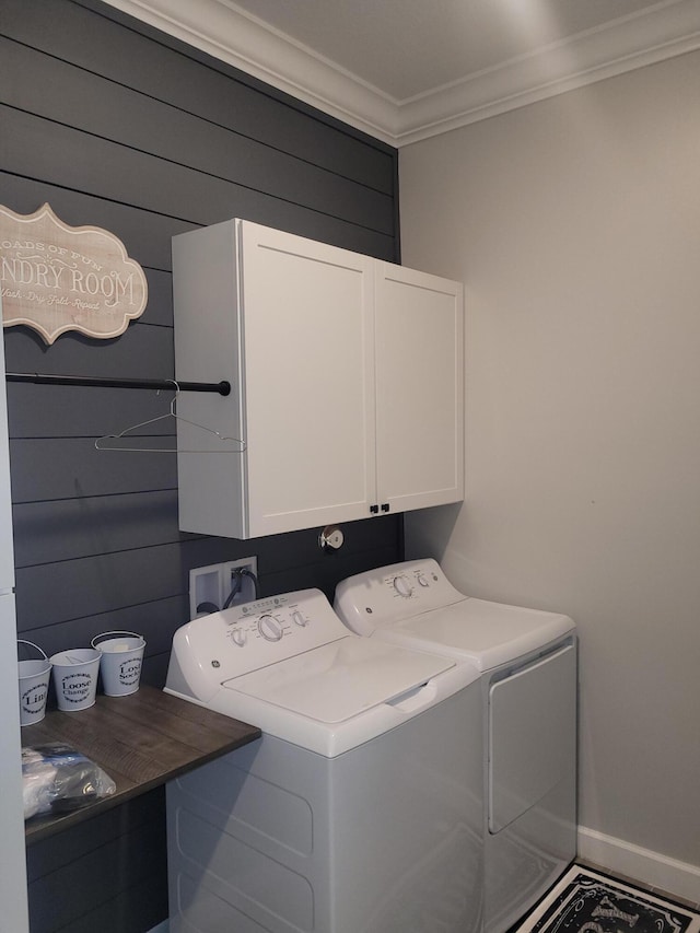 clothes washing area featuring cabinet space, crown molding, baseboards, and separate washer and dryer