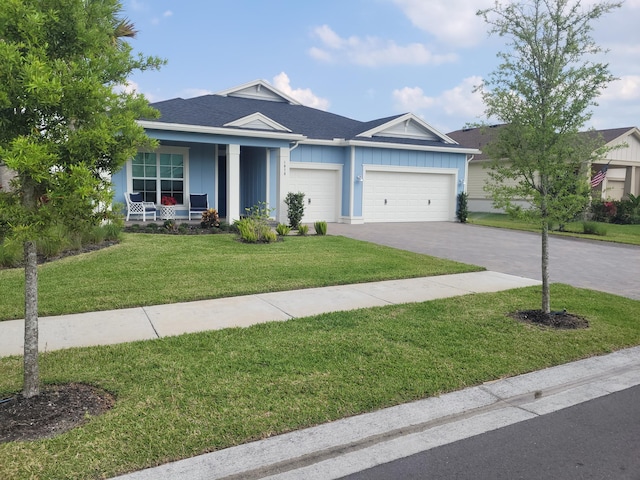 single story home with a front yard, driveway, a porch, a garage, and board and batten siding