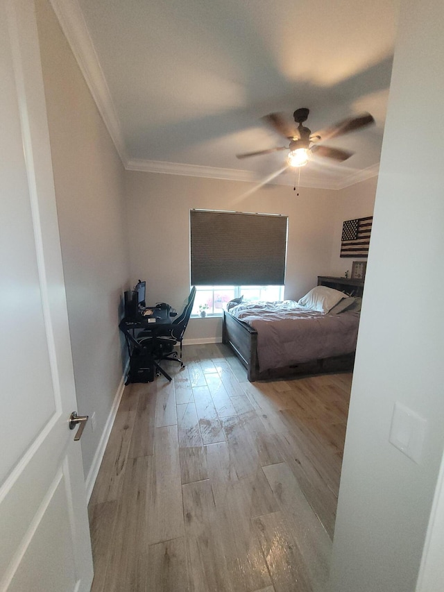 bedroom with ornamental molding, a ceiling fan, baseboards, and wood finished floors