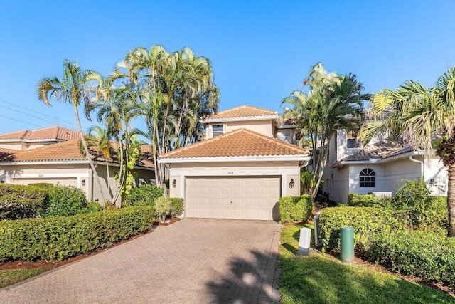 6674 NW 25th Ave, Boca Raton, FL 33496 - mediterranean / spanish home featuring decorative driveway, an attached garage, stucco siding, and a tiled roof