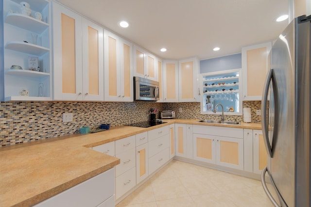 kitchen featuring light countertops, light tile patterned floors, recessed lighting, appliances with stainless steel finishes, and a sink