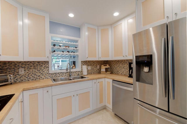 kitchen featuring a sink, light countertops, light tile patterned floors, and stainless steel appliances