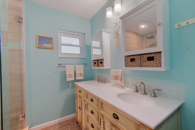 full bathroom with a sink, baseboards, a stall shower, and double vanity