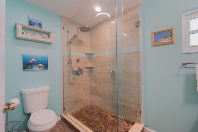 full bath featuring a shower stall, toilet, and baseboards