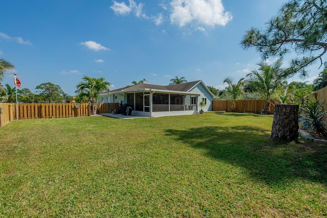 view of yard featuring a fenced backyard and a sunroom