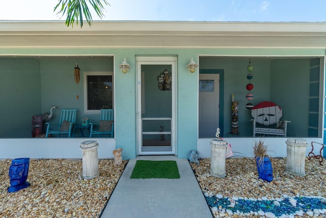 entrance to property featuring stucco siding