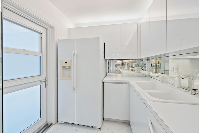 2760 S Ocean Blvd Unit 416, Palm Beach, FL 33480 - kitchen featuring white fridge with ice dispenser, a sink, light countertops, light tile patterned floors, and white cabinetry