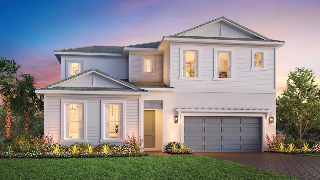 view of front facade featuring a front lawn, a garage, driveway, and stucco siding