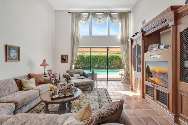 living area with tile patterned floors and a towering ceiling