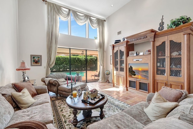 tiled living room with a high ceiling and visible vents