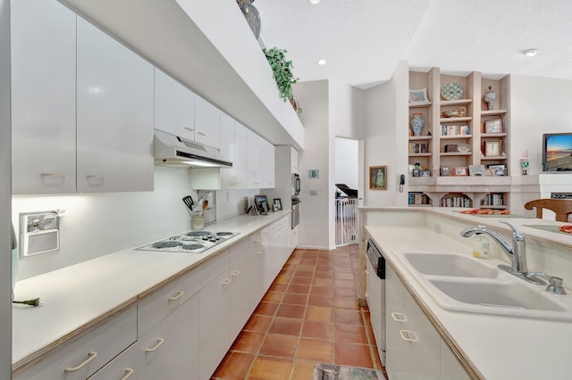 kitchen featuring under cabinet range hood, a sink, white electric cooktop, light tile patterned flooring, and light countertops