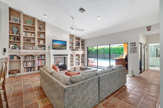 living room featuring visible vents, a ceiling fan, built in features, a textured ceiling, and lofted ceiling