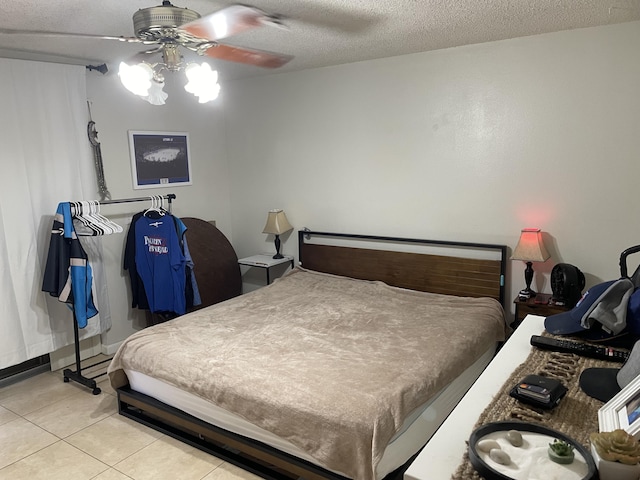 bedroom featuring light tile patterned flooring, a textured ceiling, and a ceiling fan