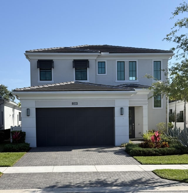 view of front of property with a garage, decorative driveway, stucco siding, and a tile roof