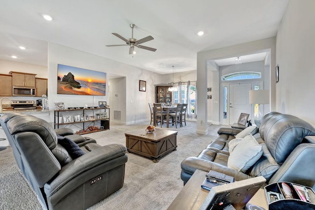 living room with recessed lighting, light colored carpet, baseboards, and ceiling fan