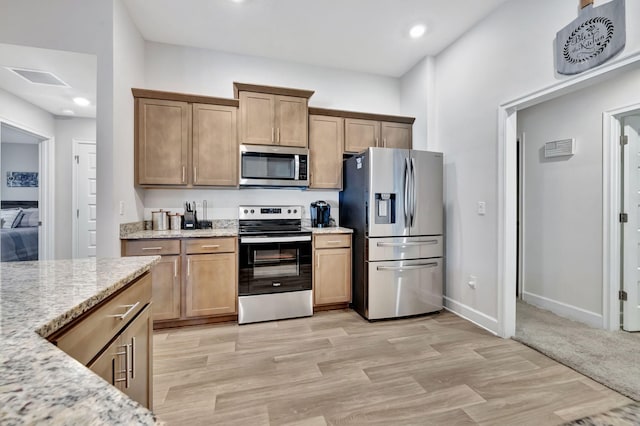 kitchen with light stone counters, baseboards, recessed lighting, light wood-style floors, and appliances with stainless steel finishes