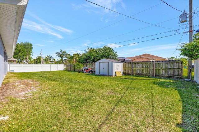 view of yard with a fenced backyard, a storage shed, and an outdoor structure