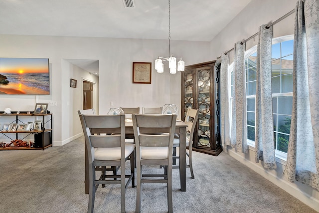 carpeted dining area with a notable chandelier, visible vents, and baseboards