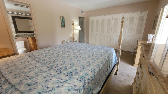 bedroom featuring connected bathroom, visible vents, a closet, and carpet flooring