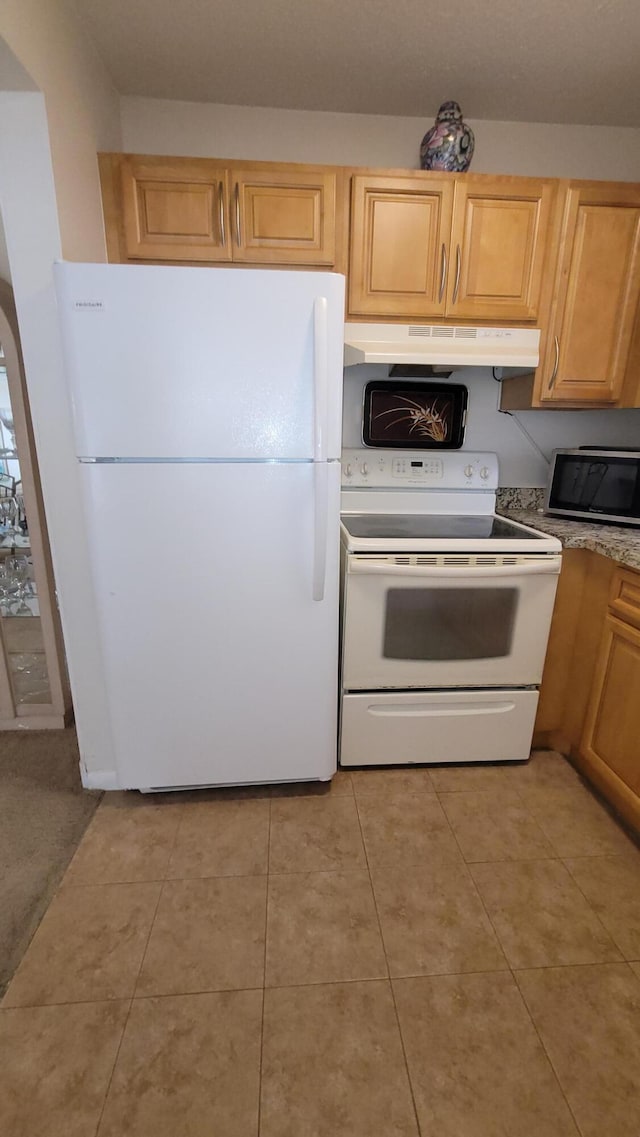 kitchen with white appliances, under cabinet range hood, and light tile patterned floors