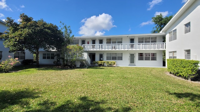 back of property featuring stucco siding and a lawn