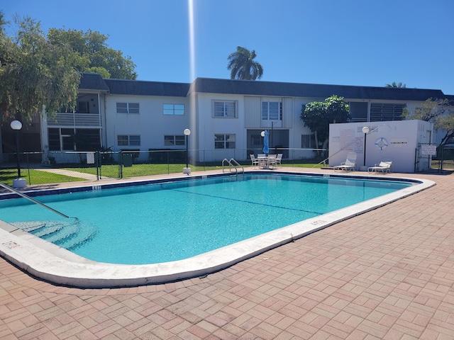 community pool featuring a patio and fence
