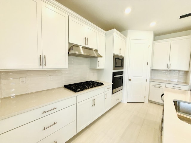 kitchen with visible vents, under cabinet range hood, stainless steel appliances, white cabinets, and light countertops