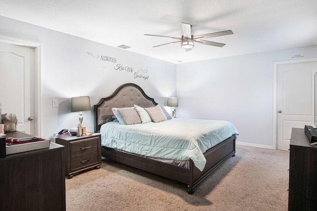 bedroom featuring visible vents, light colored carpet, baseboards, and ceiling fan