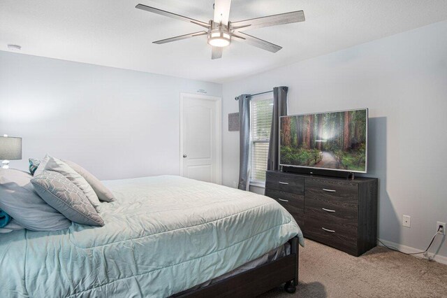 bedroom with light carpet, baseboards, and a ceiling fan